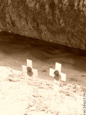 petites croix d&eacute;pos&eacute;es par des survivants sur la plage.